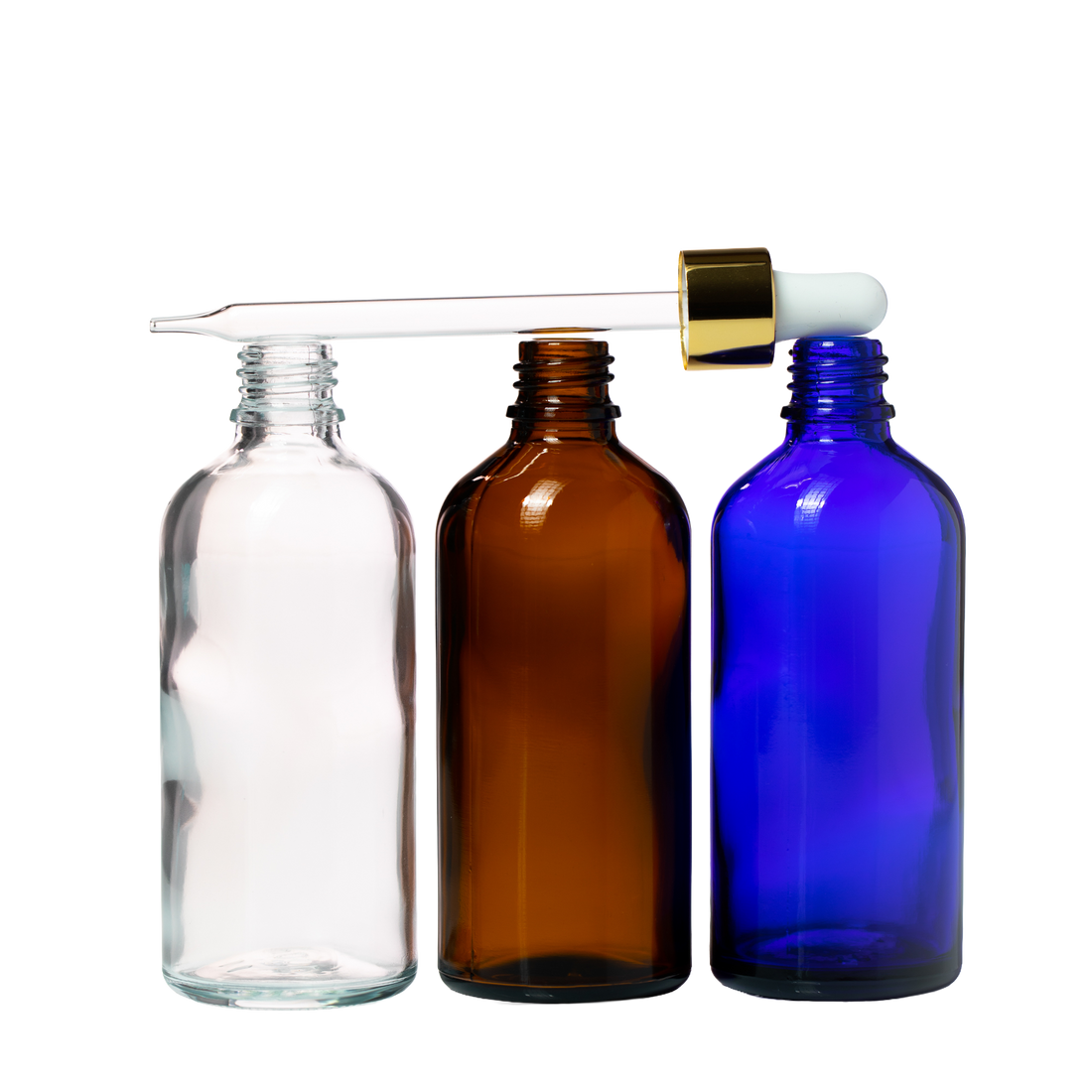 Clear, amber, and blue glass bottle with gold dropper top resting on top of the bottle 